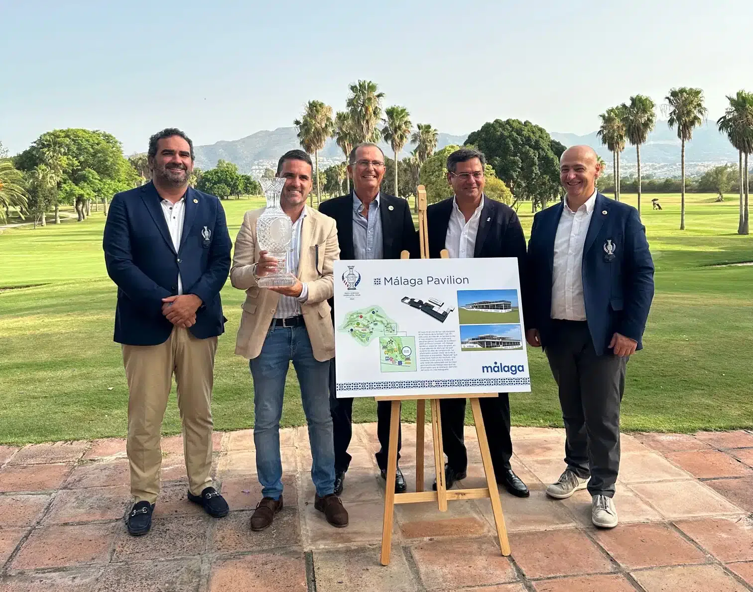A group of men showing well-being while posing for a photo in front of a golf course.