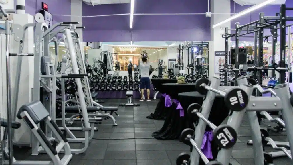 A gymnasium for lease with a large amount of equipment and purple walls.